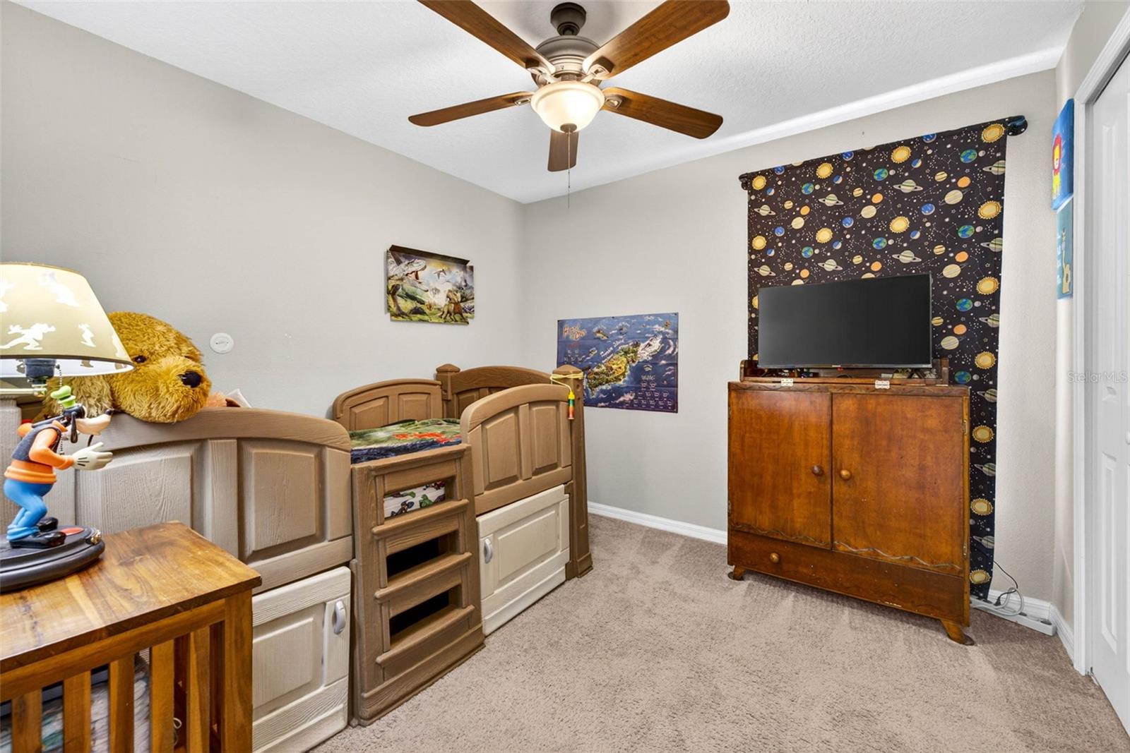 Secondary bedroom with ceiing fan and built in closet