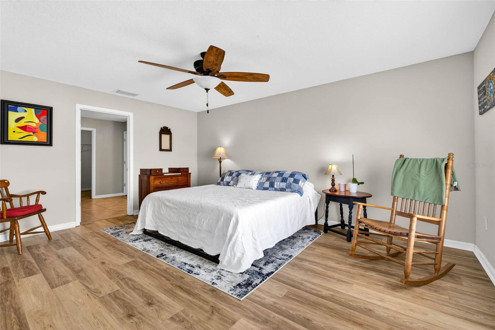 Primary bedroom with en suite bathroom, luxury vinyl plank flooring and ceiling fan