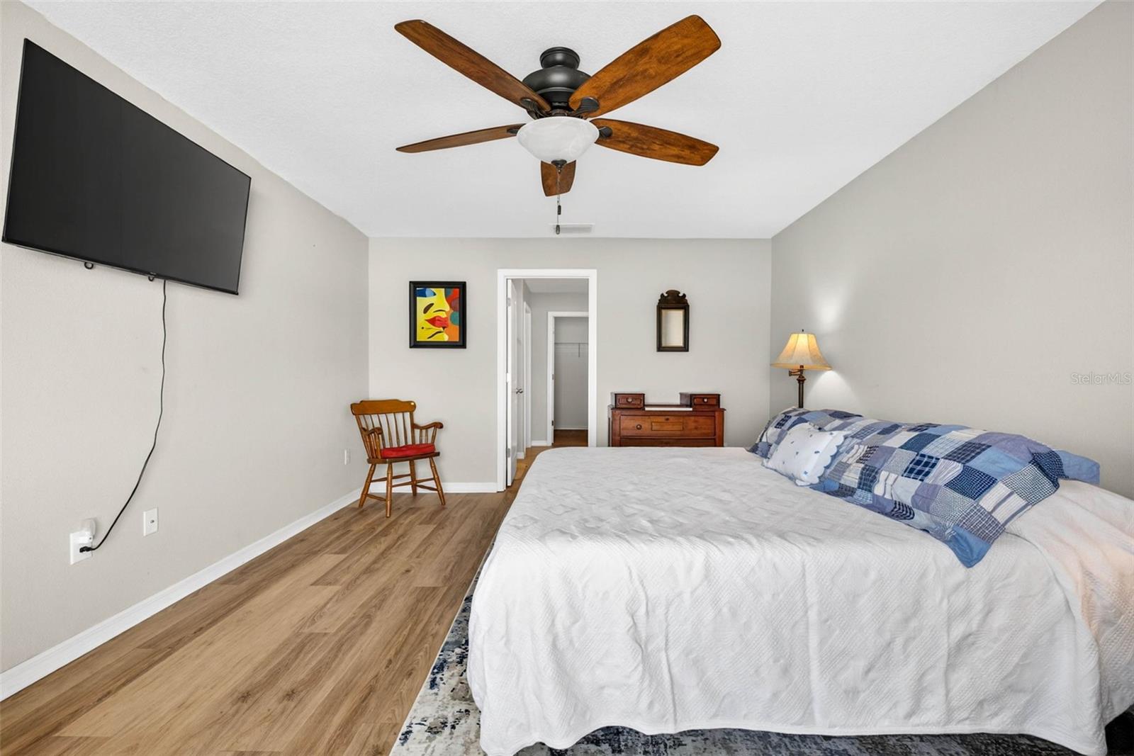 Primary bedroom with ceiling fan, en suite bathroom and luxury vinyl plank flooring.