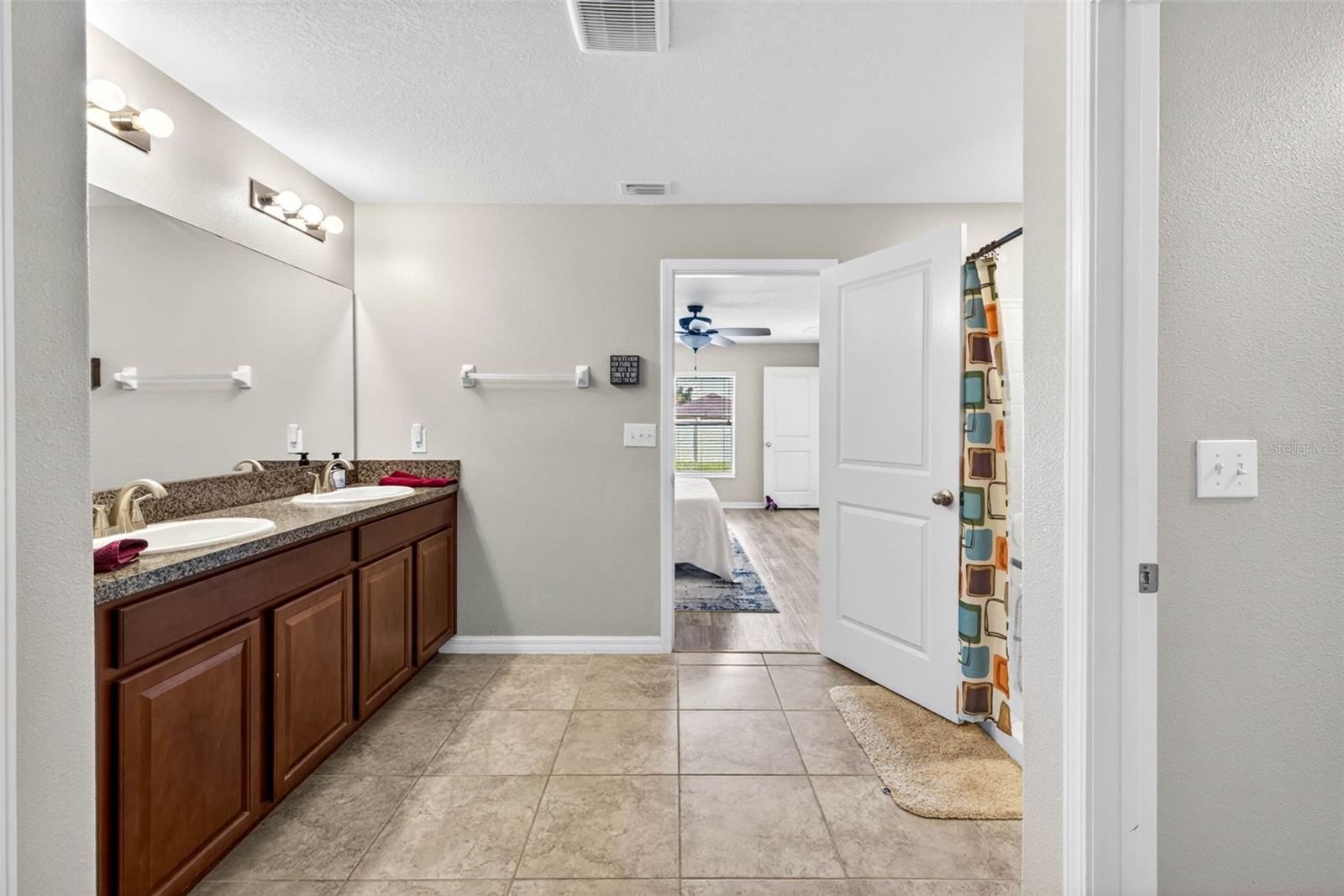 En suite primary bathroom with dual sinks in comfort height vanity.