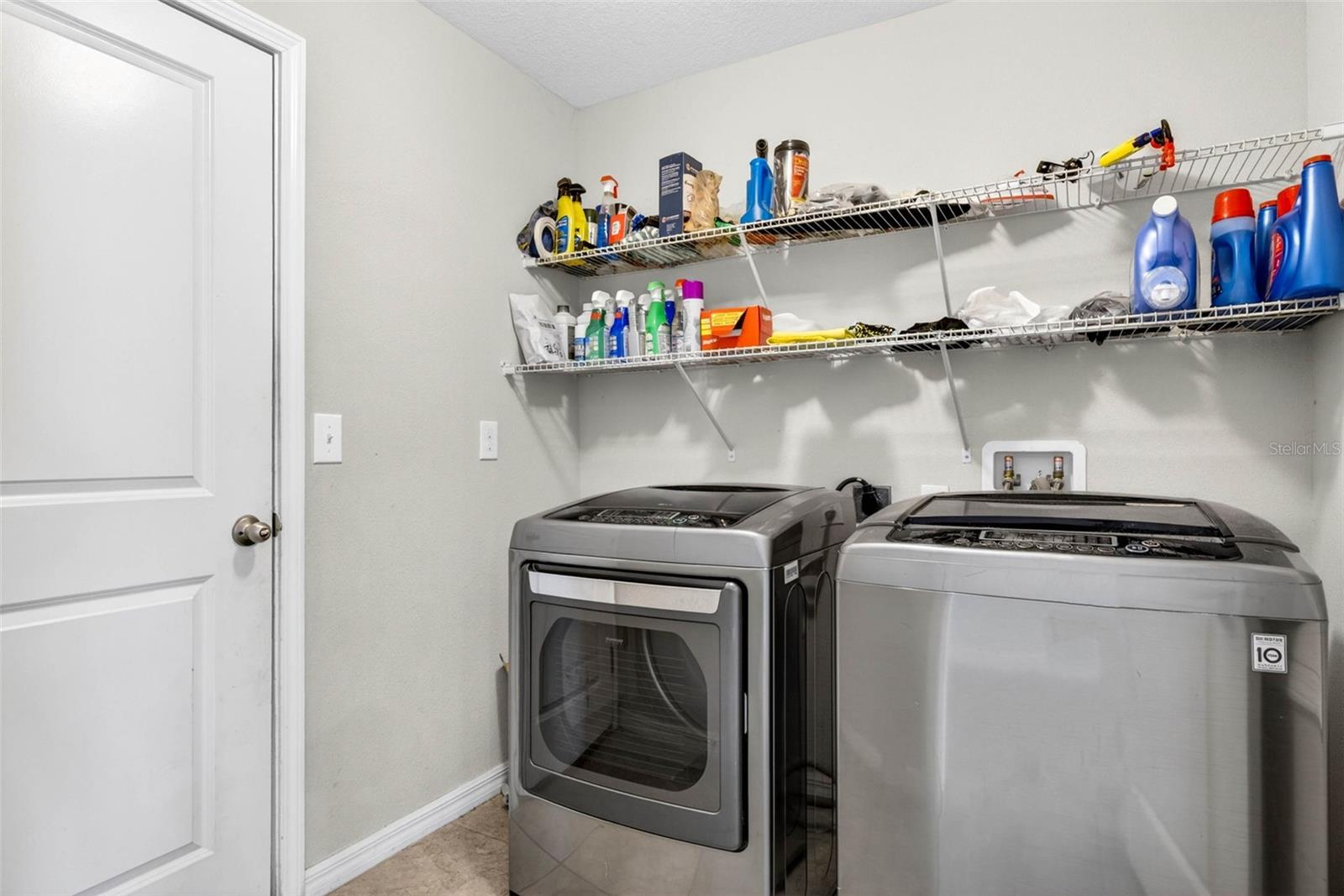 Laundry room with shelving. Washer and dryer do convey.
