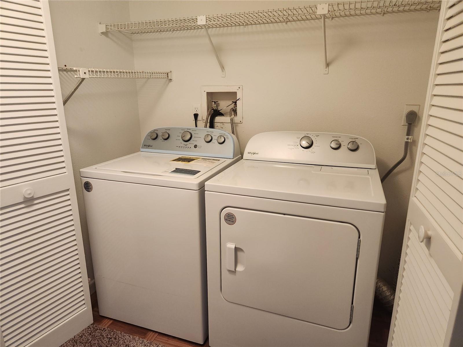Laundry closet in hallway  off guest bedroom with newer full size washer & dryer.