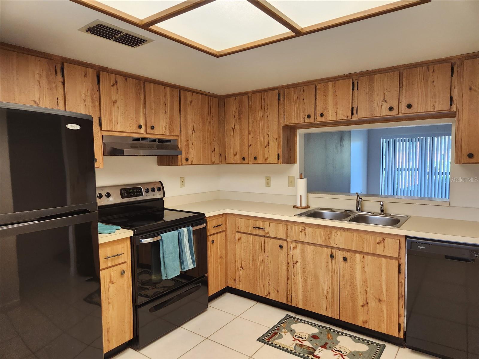 Kitchen has tons of cabinets and counter space.  Pass through window to dining room.