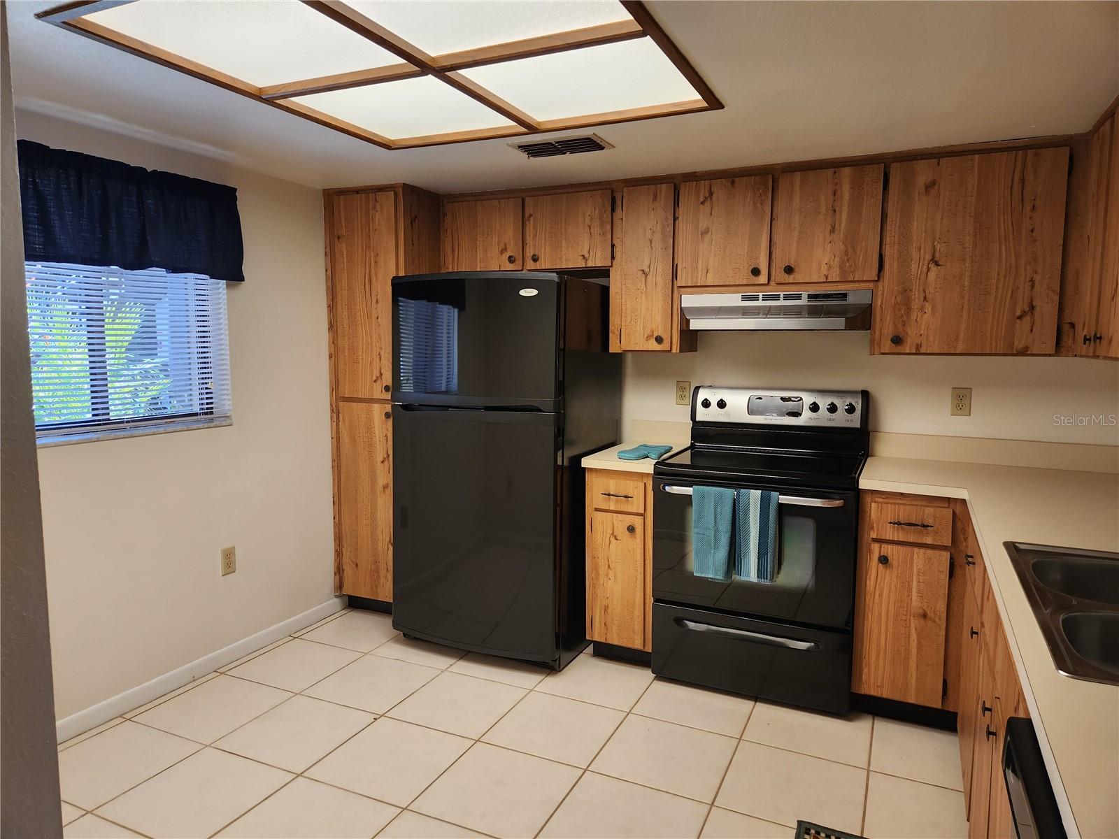 Another view of kitchen.  Small pantry closet next to refrigerator.  Room for small cafe table.