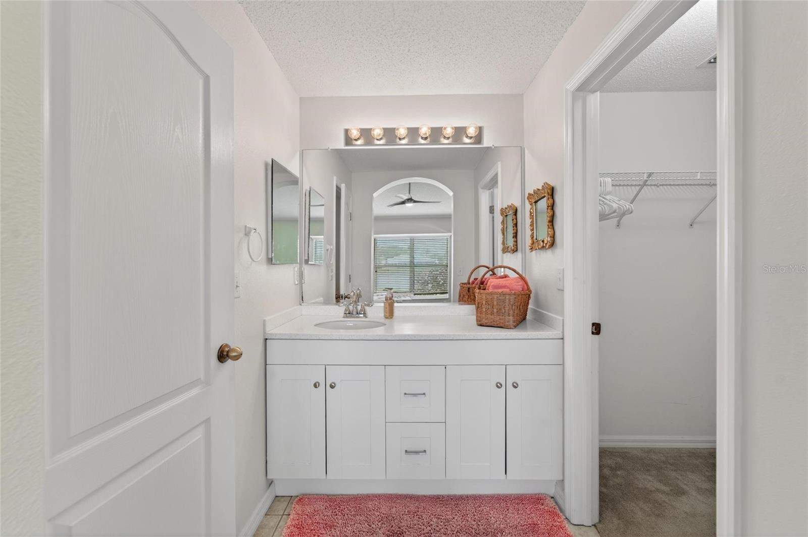 primary bath with walk in closet on the right and toilet room and shower on left