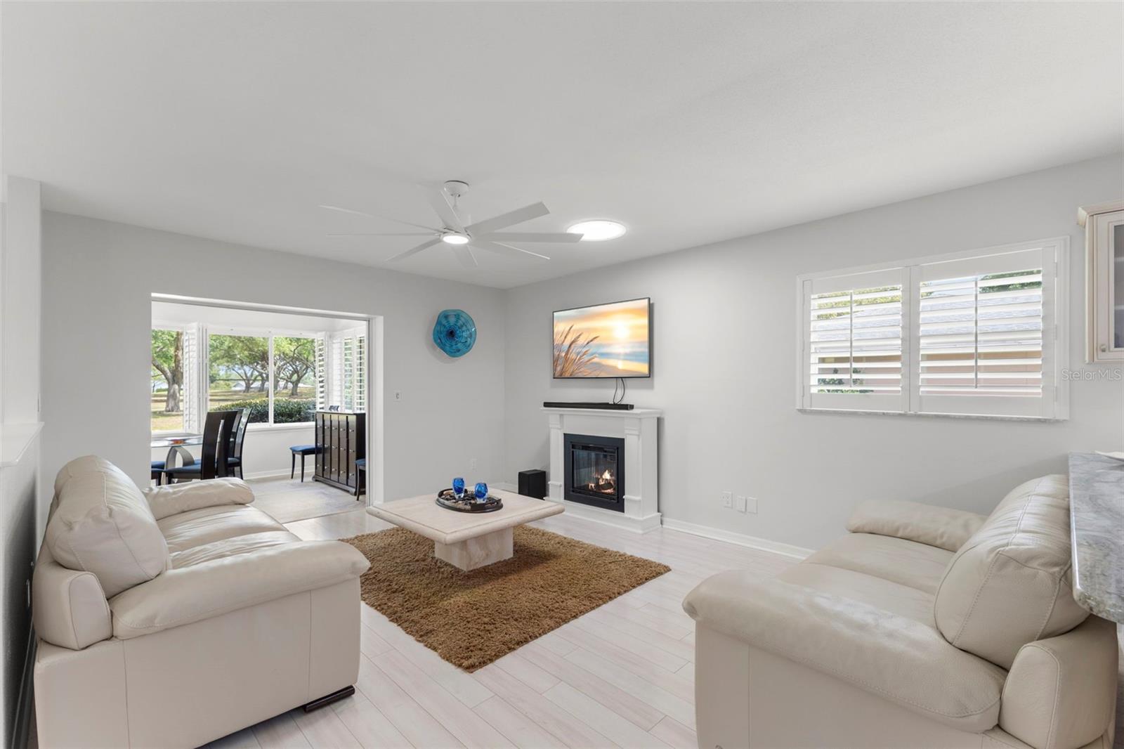 FAMILY TV ROOM LOOKING OUT TO FAIRWAY AND BACKYARD WITH PAVED SITTING AREA