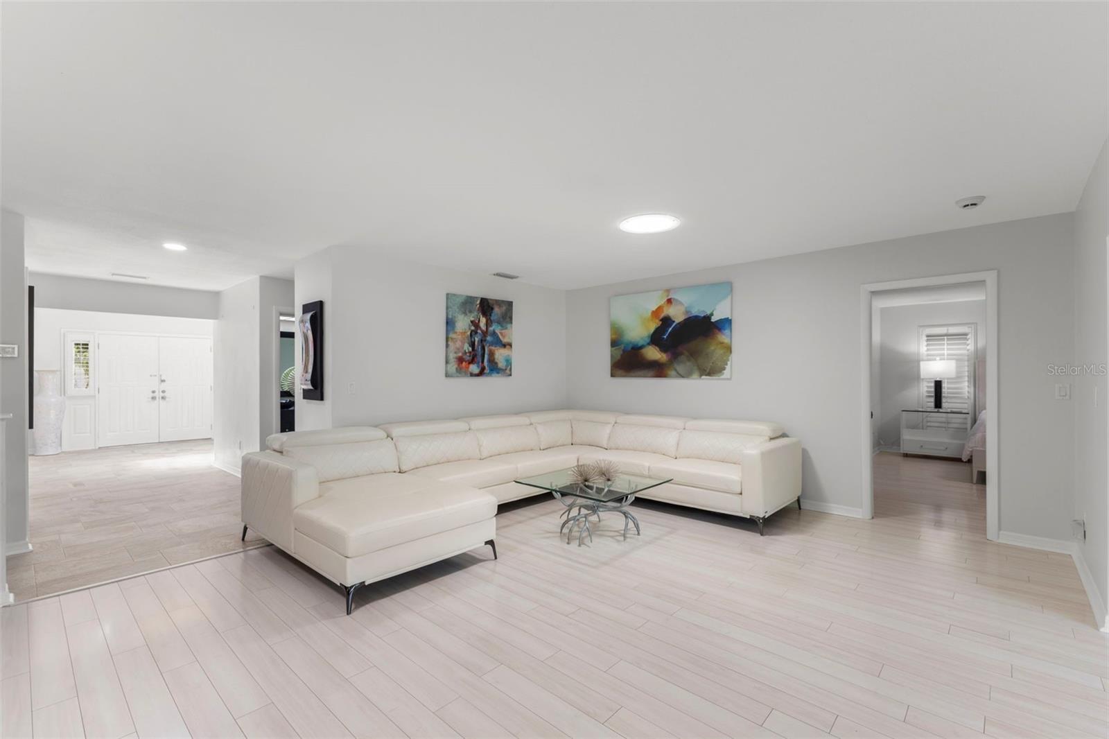 VIEW FROM LARGE LIVING ROOM TO FRONT DOOR TO MASTER