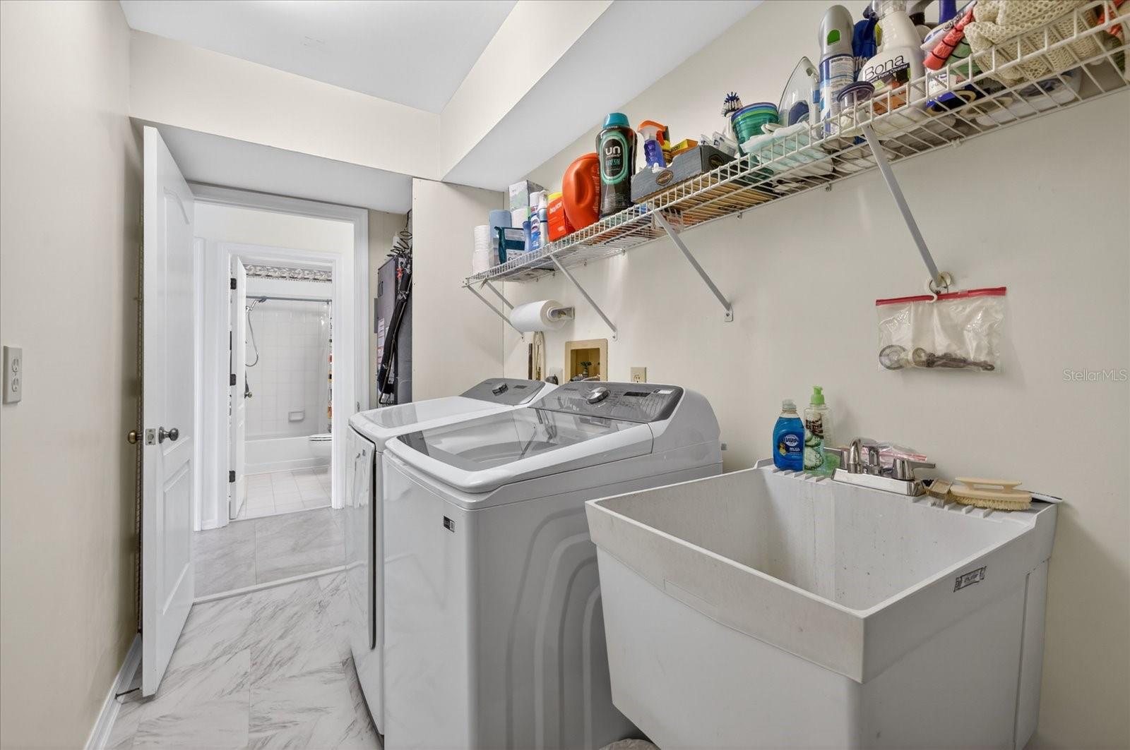 Laundry room with sink W/D and laudry chute from primary closet behind door.