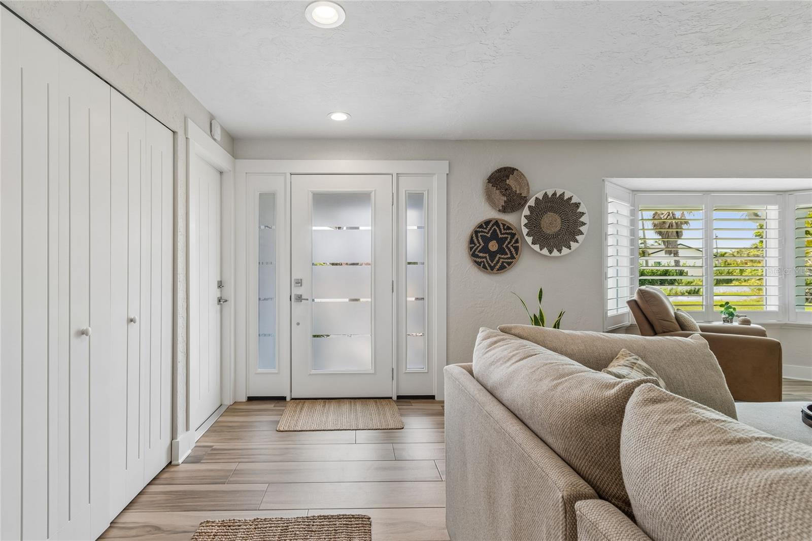 Entry with custom doors, storage closet with built-ins