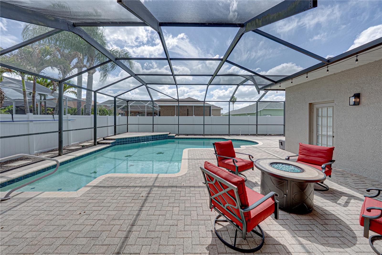 Expansive outdoor living with a large lanai, pool, and lounge area, all set in a low-maintenance backyard designed for effortless Florida living and entertaining.