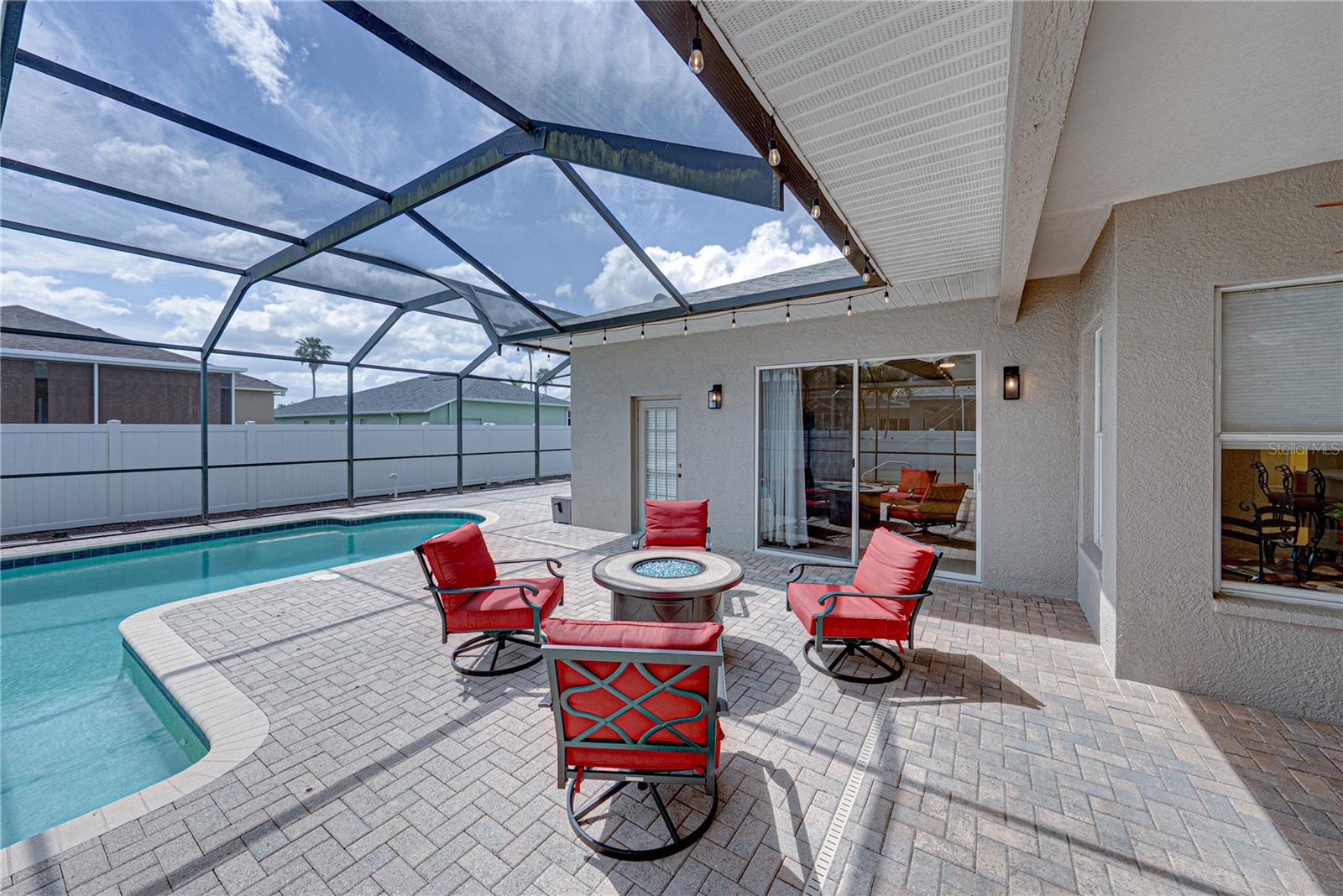 Expansive outdoor living with a large lanai, pool, and lounge area, all set in a low-maintenance backyard designed for effortless Florida living and entertaining.