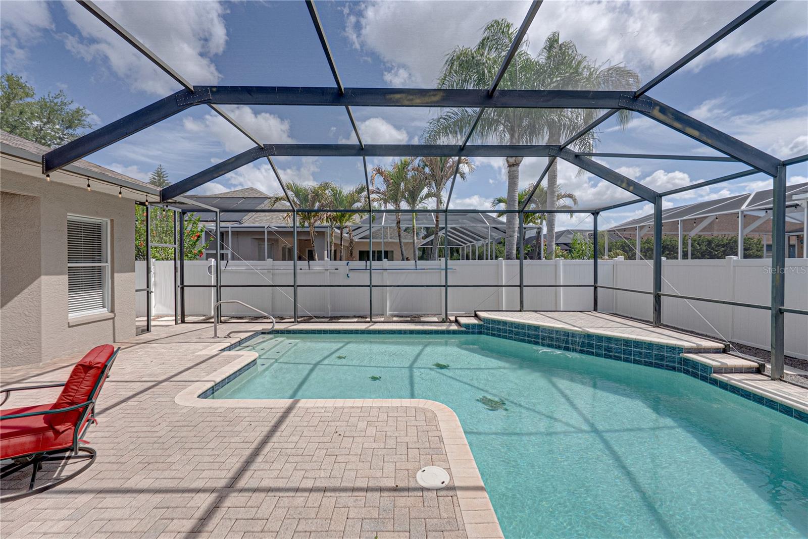 Expansive outdoor living with a large lanai, pool, and lounge area, all set in a low-maintenance backyard designed for effortless Florida living and entertaining.