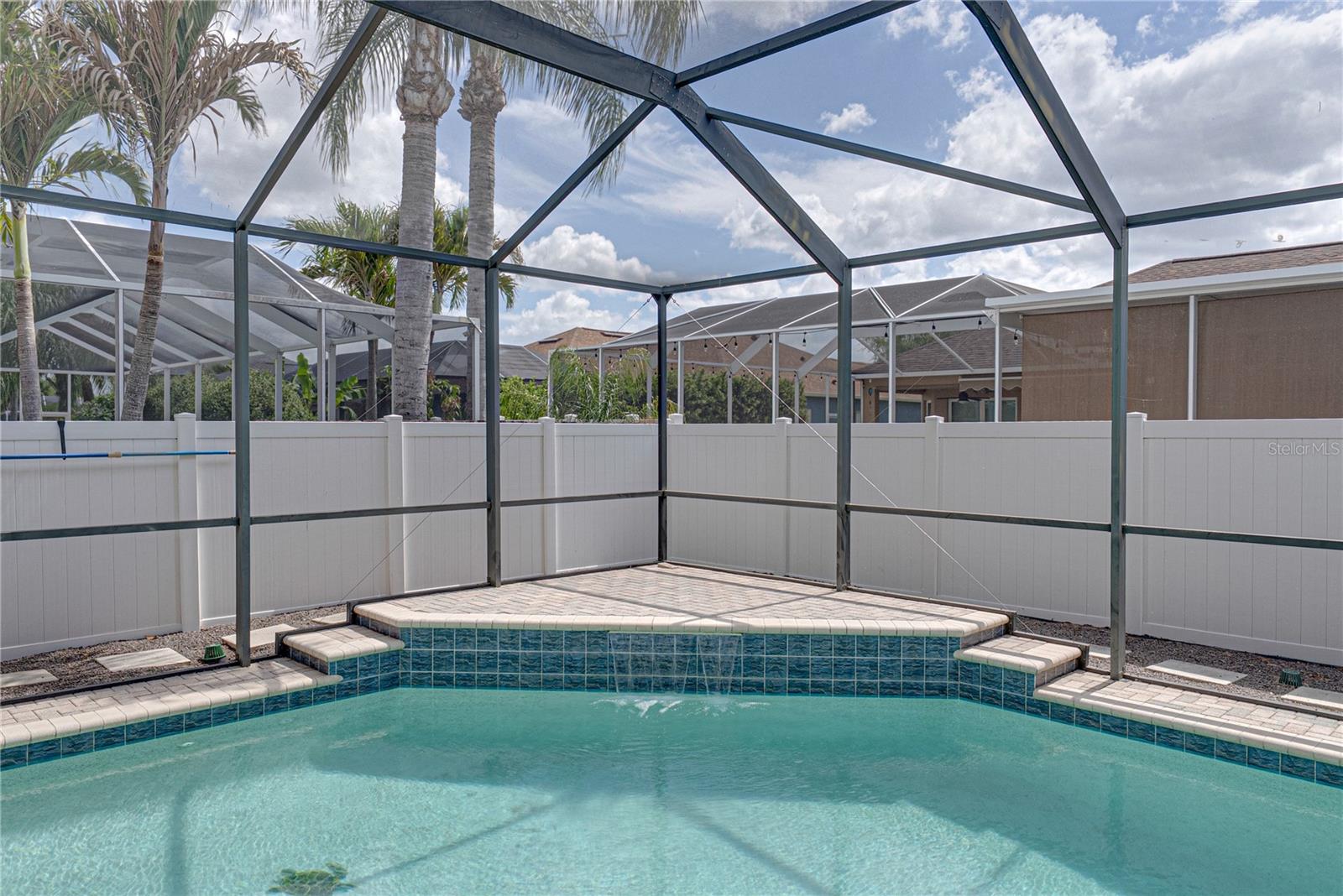Expansive outdoor living with a large lanai, pool, and lounge area, all set in a low-maintenance backyard designed for effortless Florida living and entertaining.
