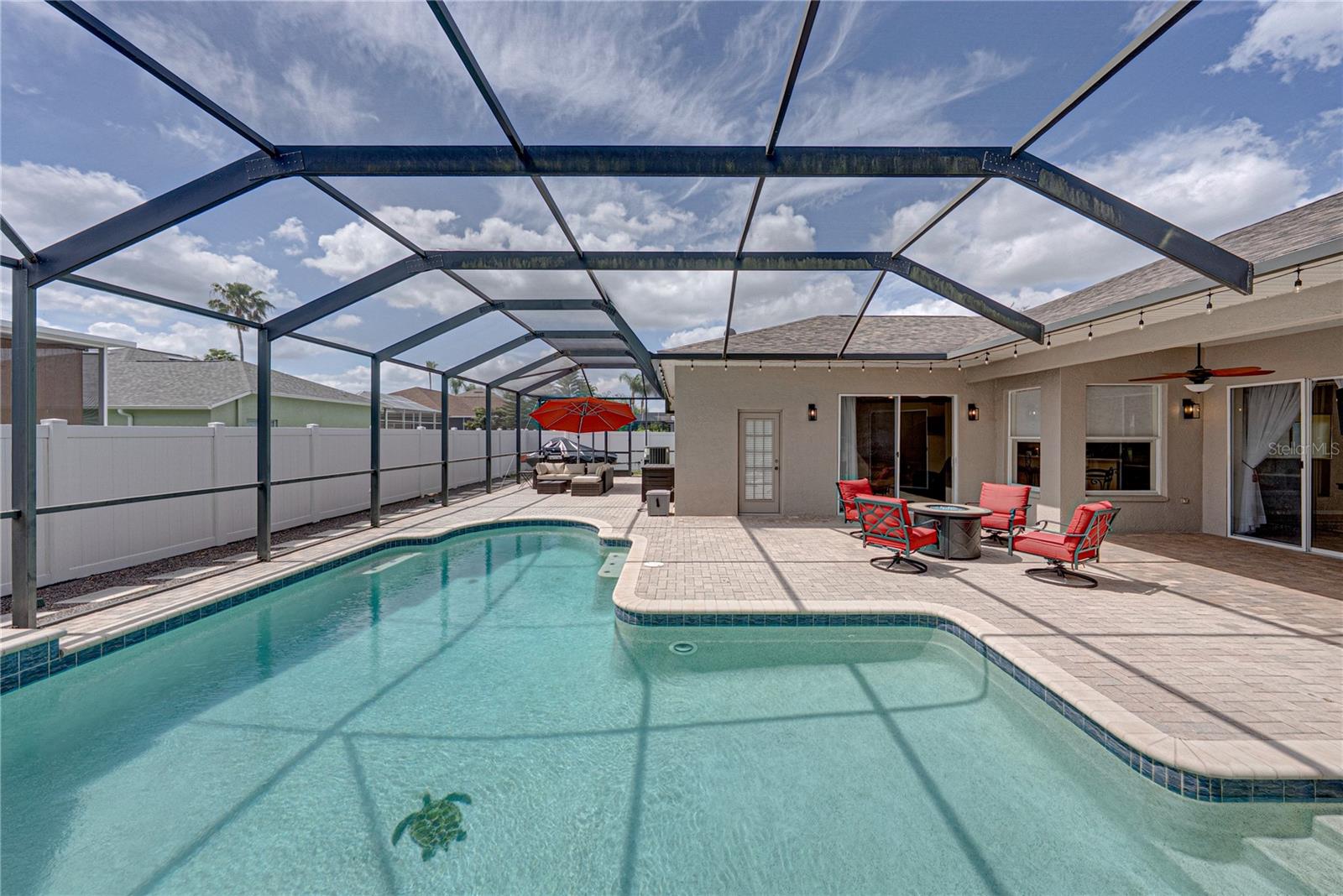 Expansive outdoor living with a large lanai, pool, and lounge area, all set in a low-maintenance backyard designed for effortless Florida living and entertaining.
