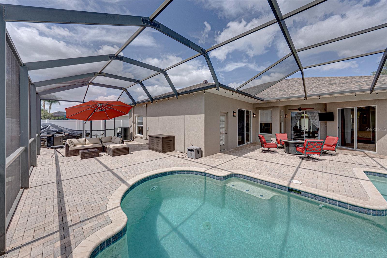 Expansive outdoor living with a large lanai, pool, and lounge area, all set in a low-maintenance backyard designed for effortless Florida living and entertaining.