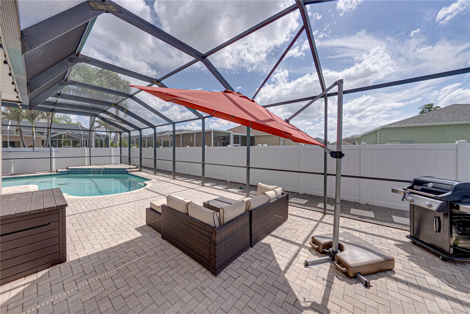 Expansive outdoor living with a large lanai, pool, and lounge area, all set in a low-maintenance backyard designed for effortless Florida living and entertaining.