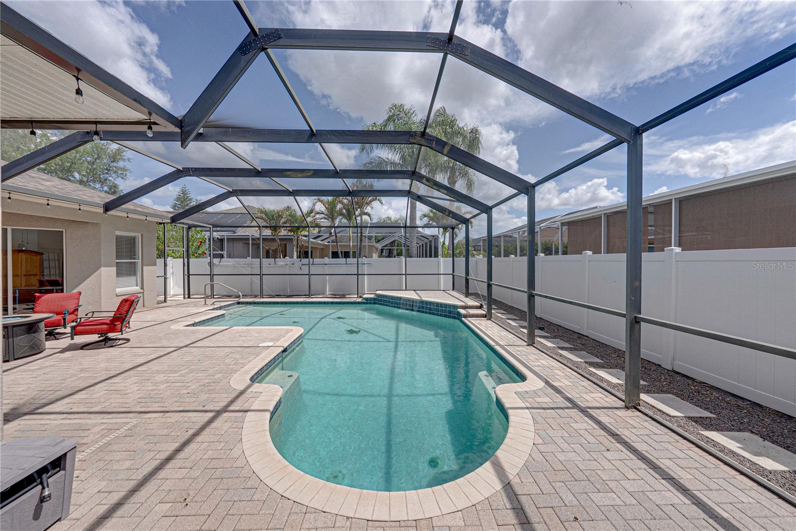 Expansive outdoor living with a large lanai, pool, and lounge area, all set in a low-maintenance backyard designed for effortless Florida living and entertaining.