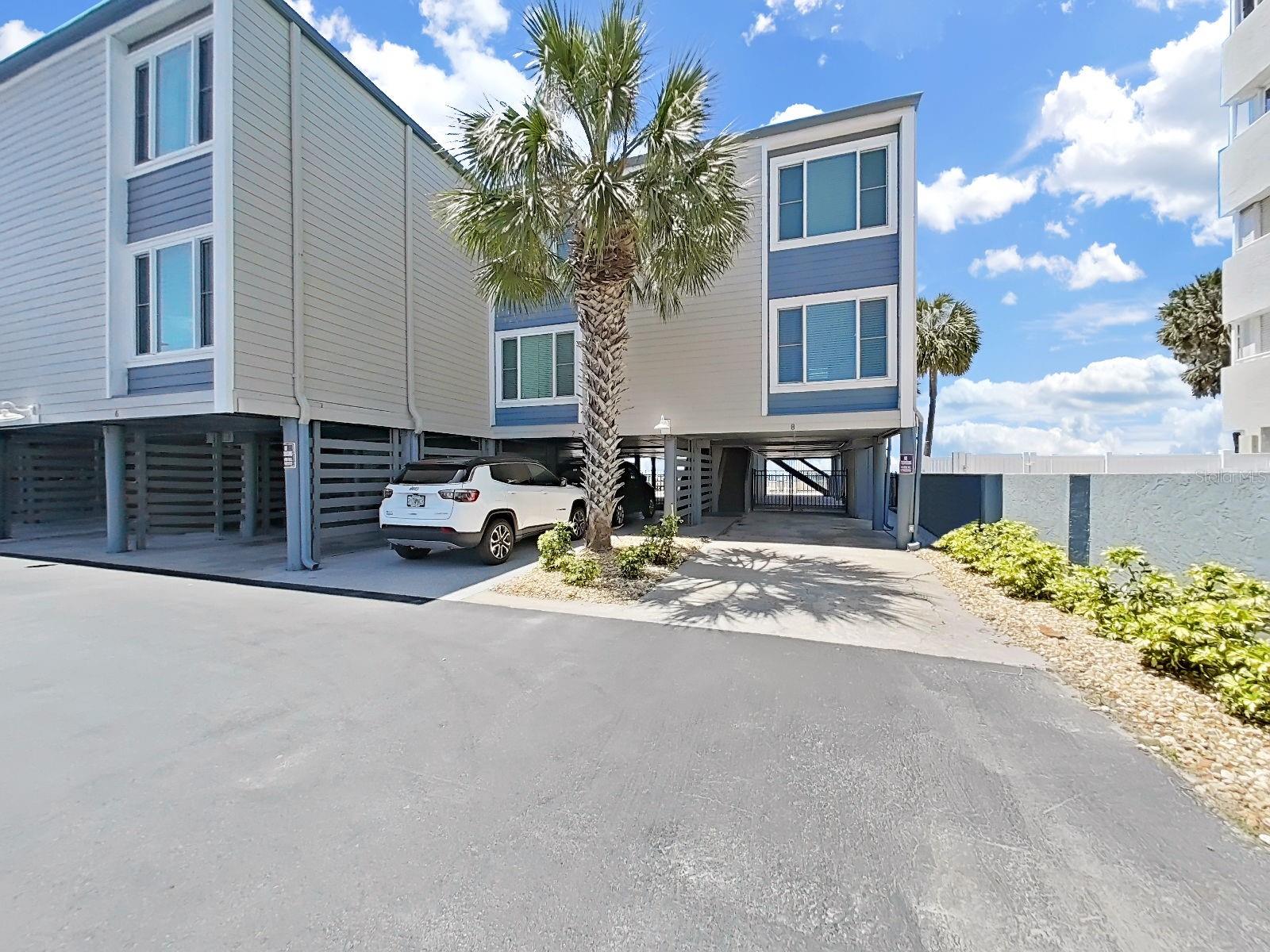 Corner unit with covered carport and extra covered entertainment area with direct access to the beach.