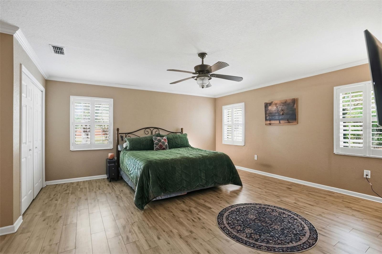 Oversized Primary Bedroom with Easy to Maintain Wood-Look Tile Floors, 3 Walk-in Closets, 2 Double Door Linen Closets and 2 separate vanity countertops with sinks