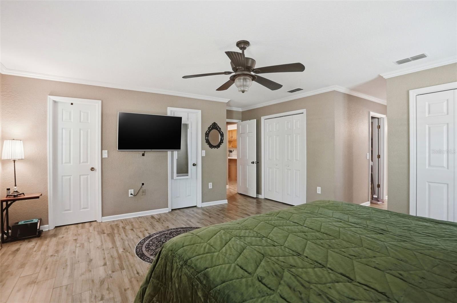 Oversized Primary Bedroom with Easy to Maintain Wood-Look Tile Floors, 3 Walk-in Closets, 2 Double Door Linen Closets and 2 separate vanity countertops with sinks