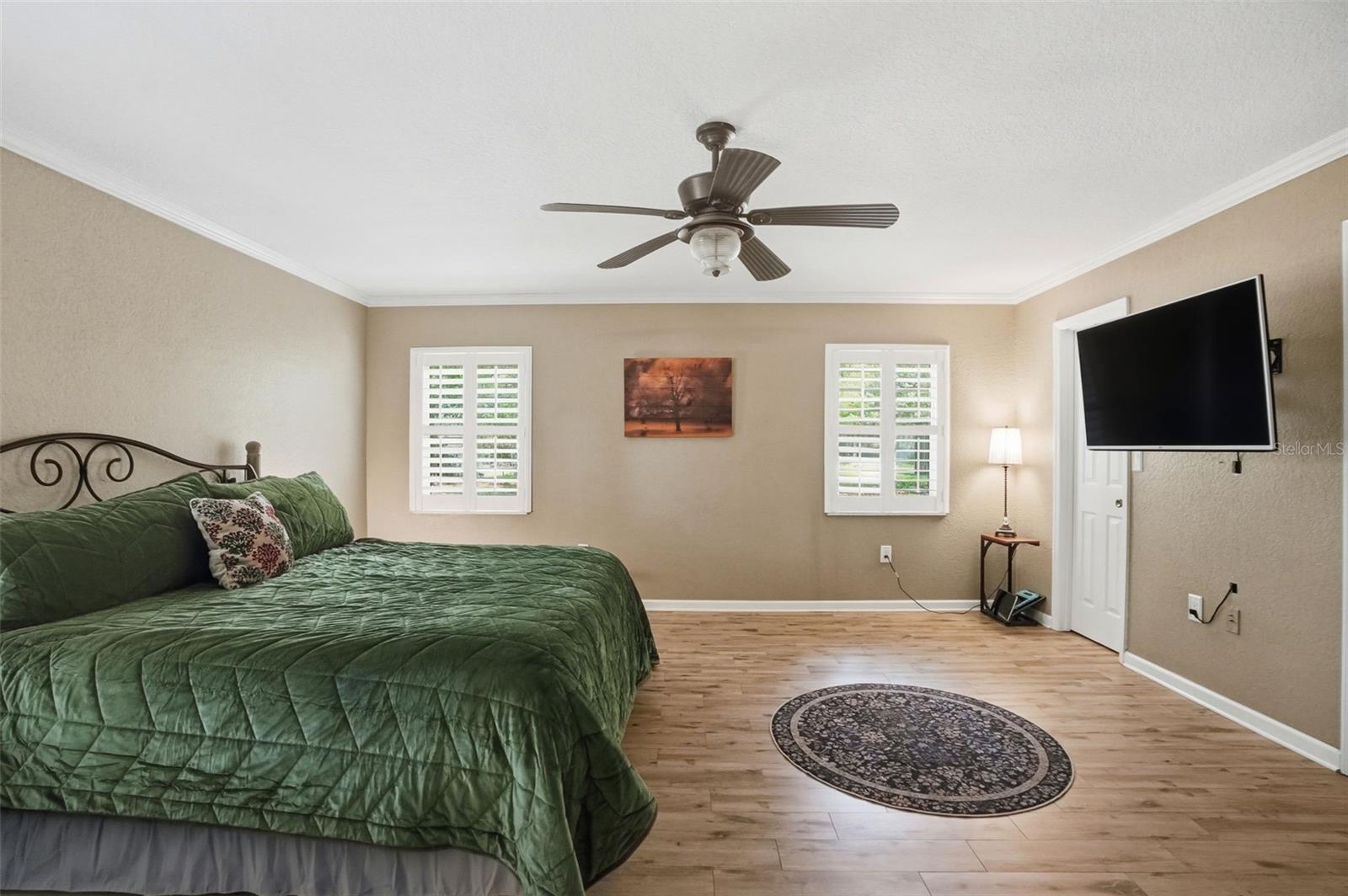 Oversized Primary Bedroom with Easy to Maintain Wood-Look Tile Floors, 3 Walk-in Closets, 2 Double Door Linen Closets and 2 separate vanity countertops with sinks