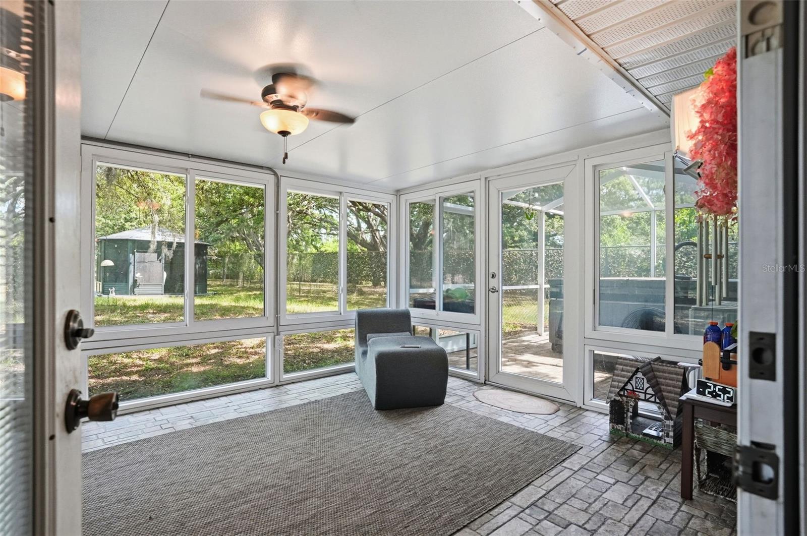 Heated and Cooled Sunroom with Glass Windows, Double French Doors to the Living Room, Door the Backyard and another Door to the Screen Enclosed Hot Tub
