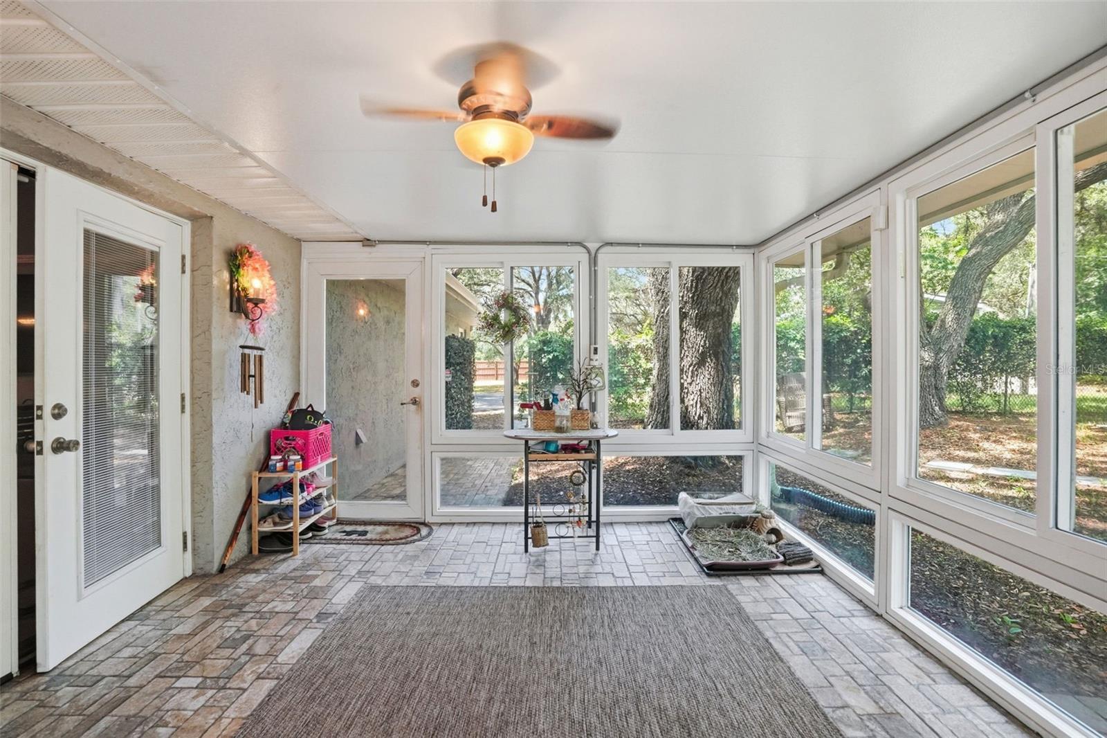 Heated and Cooled Sunroom with Glass Windows, Double French Doors to the Living Room, Door the Backyard and another Door to the Screen Enclosed Hot Tub