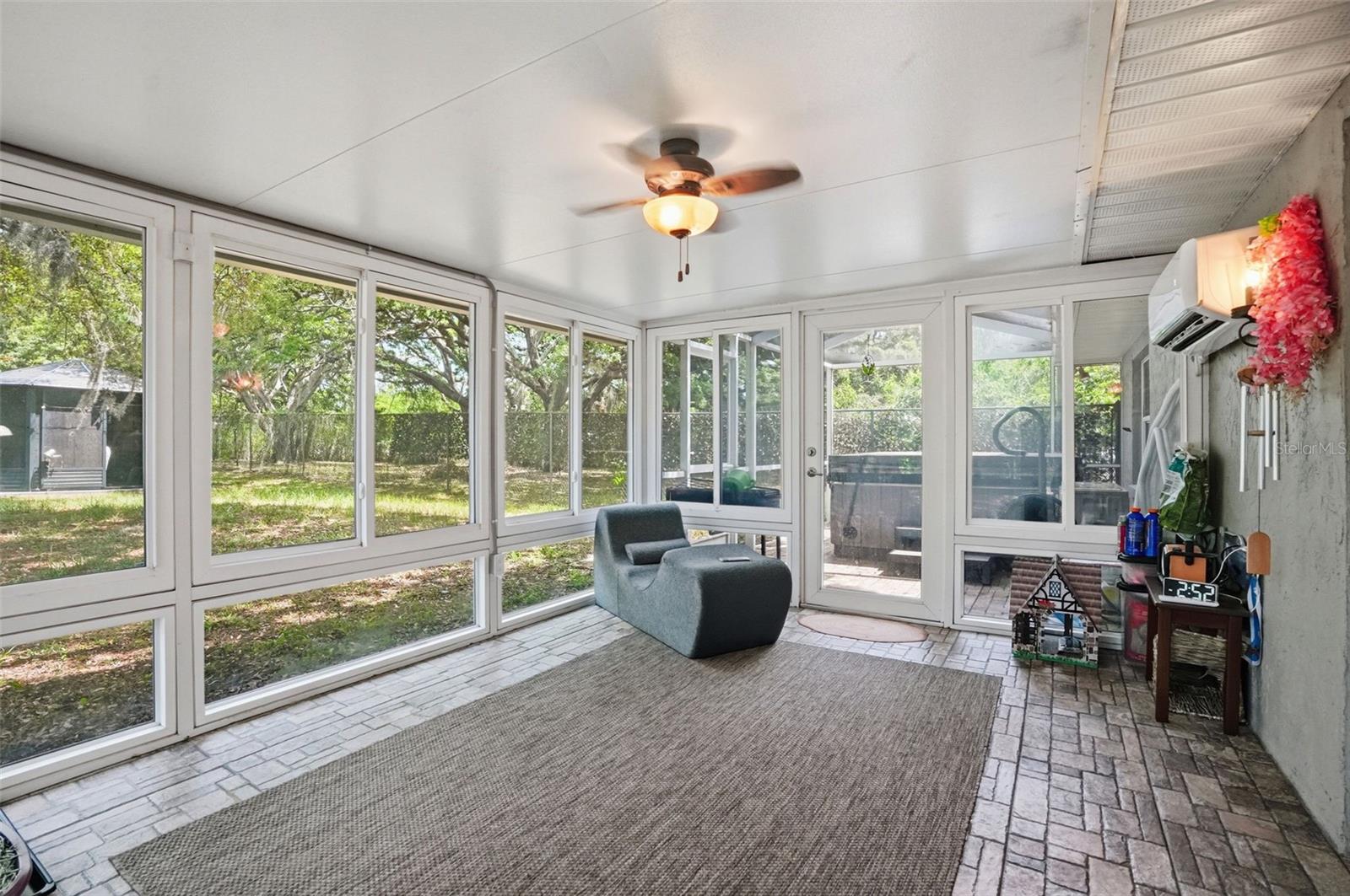 Heated and Cooled Sunroom with Glass Windows, Double French Doors to the Living Room, Door the Backyard and another Door to the Screen Enclosed Hot Tub