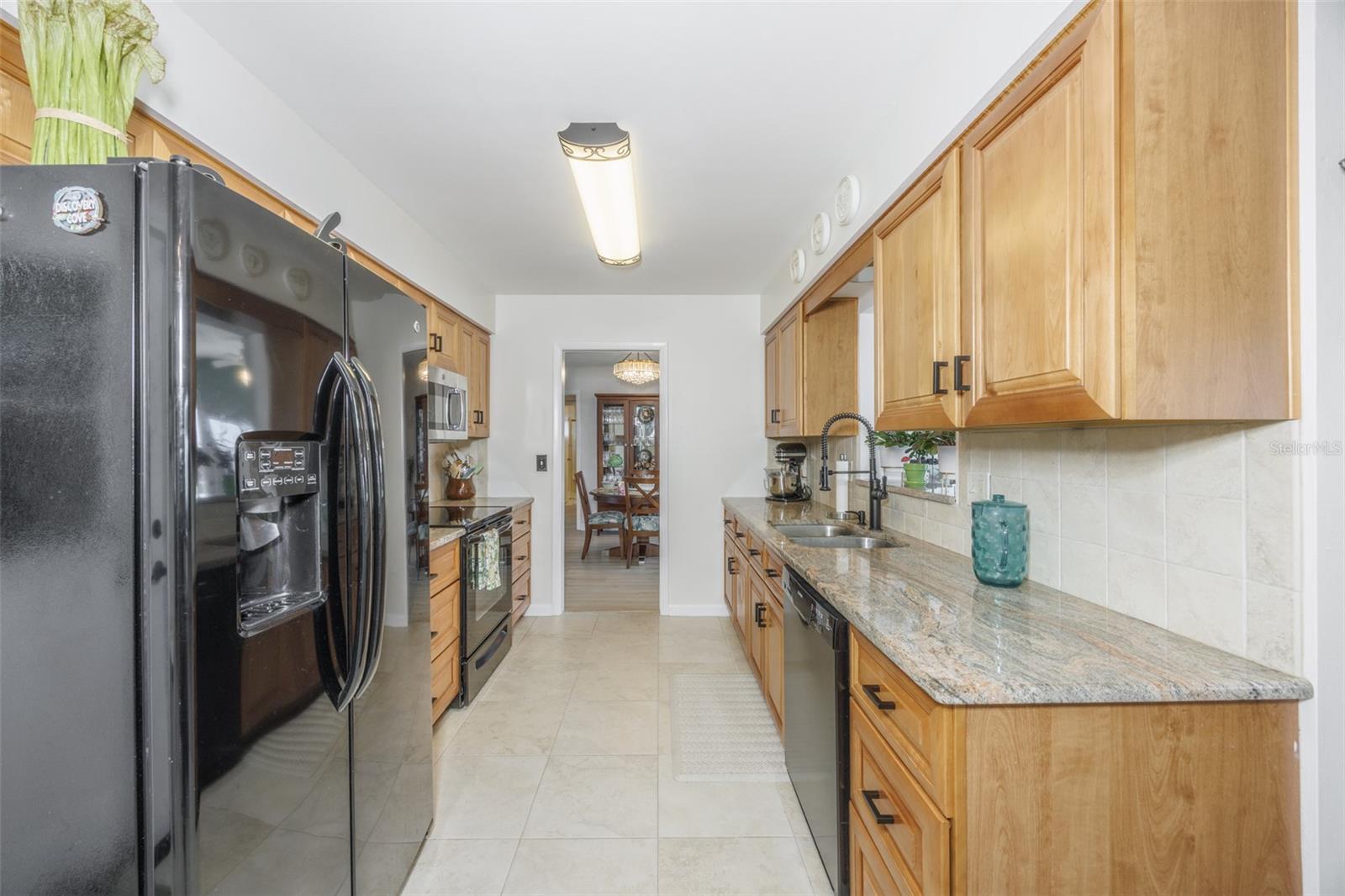 Galley Kitchen, Wood Cabinets, Granite Countertops, Pass Through to Enclosed Lanai