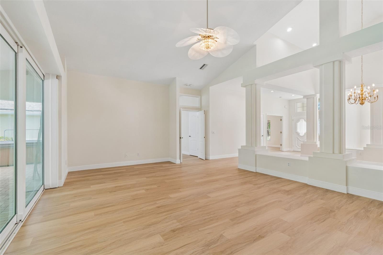 Now onto your giant family/great room with massive, hurricane impact sliders overlooking a covered patio and screened and heated pool!