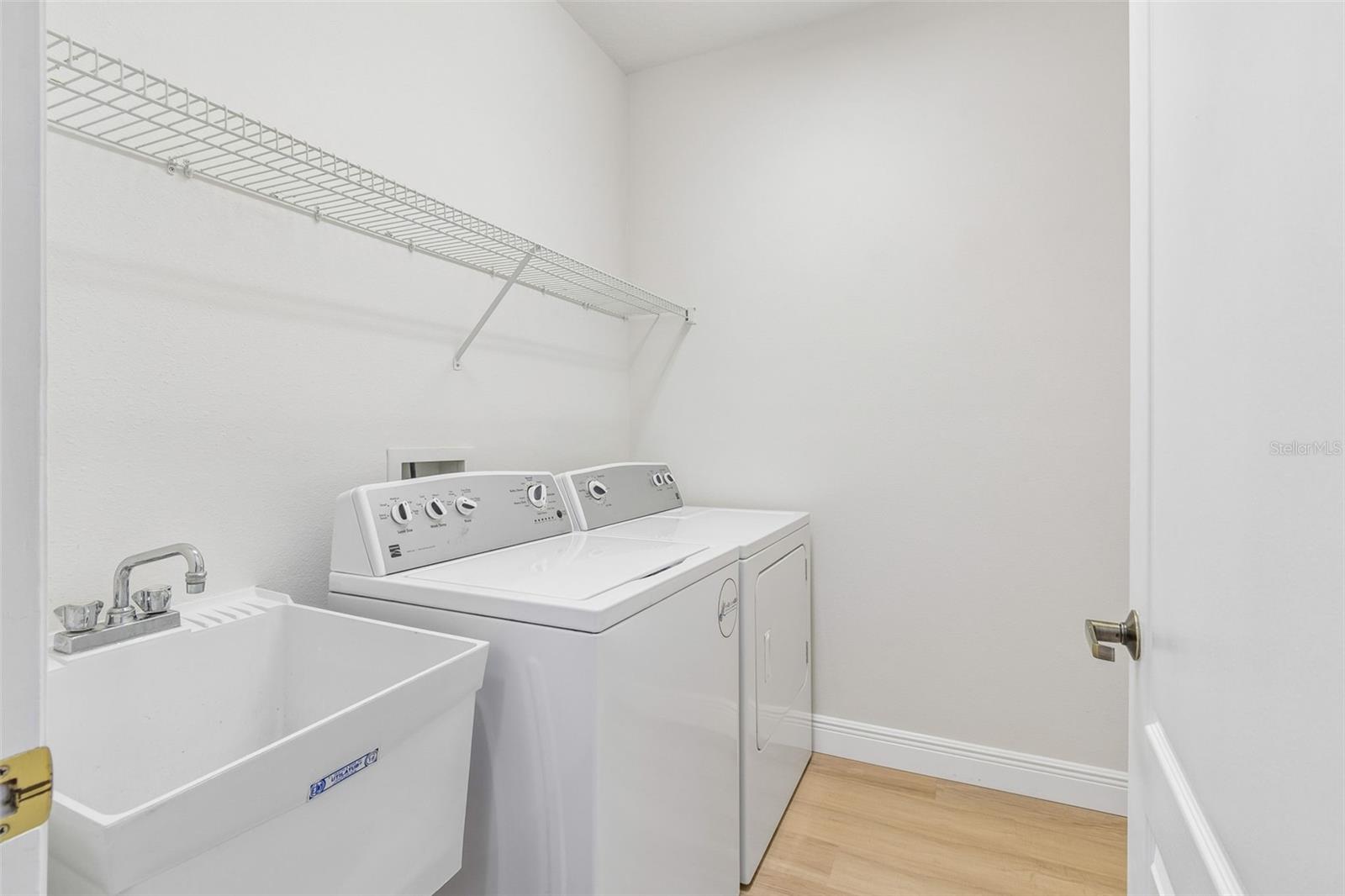 Inside laundry room has plenty of space and perfectly positioned next to kitchen and garage entry.