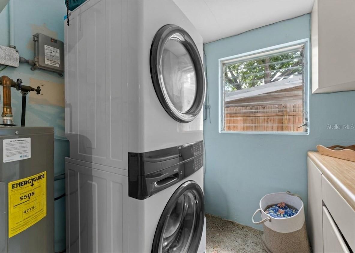 Large interior laundry room with stackable washer and dryer