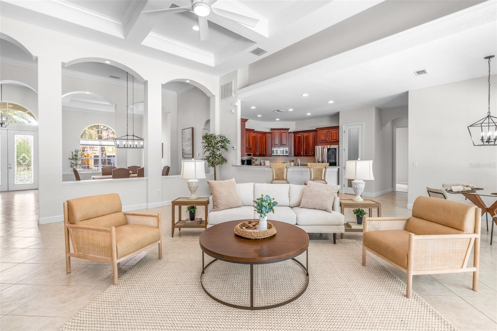 Bright and inviting great room with coffered ceilings and picturesque conservation views