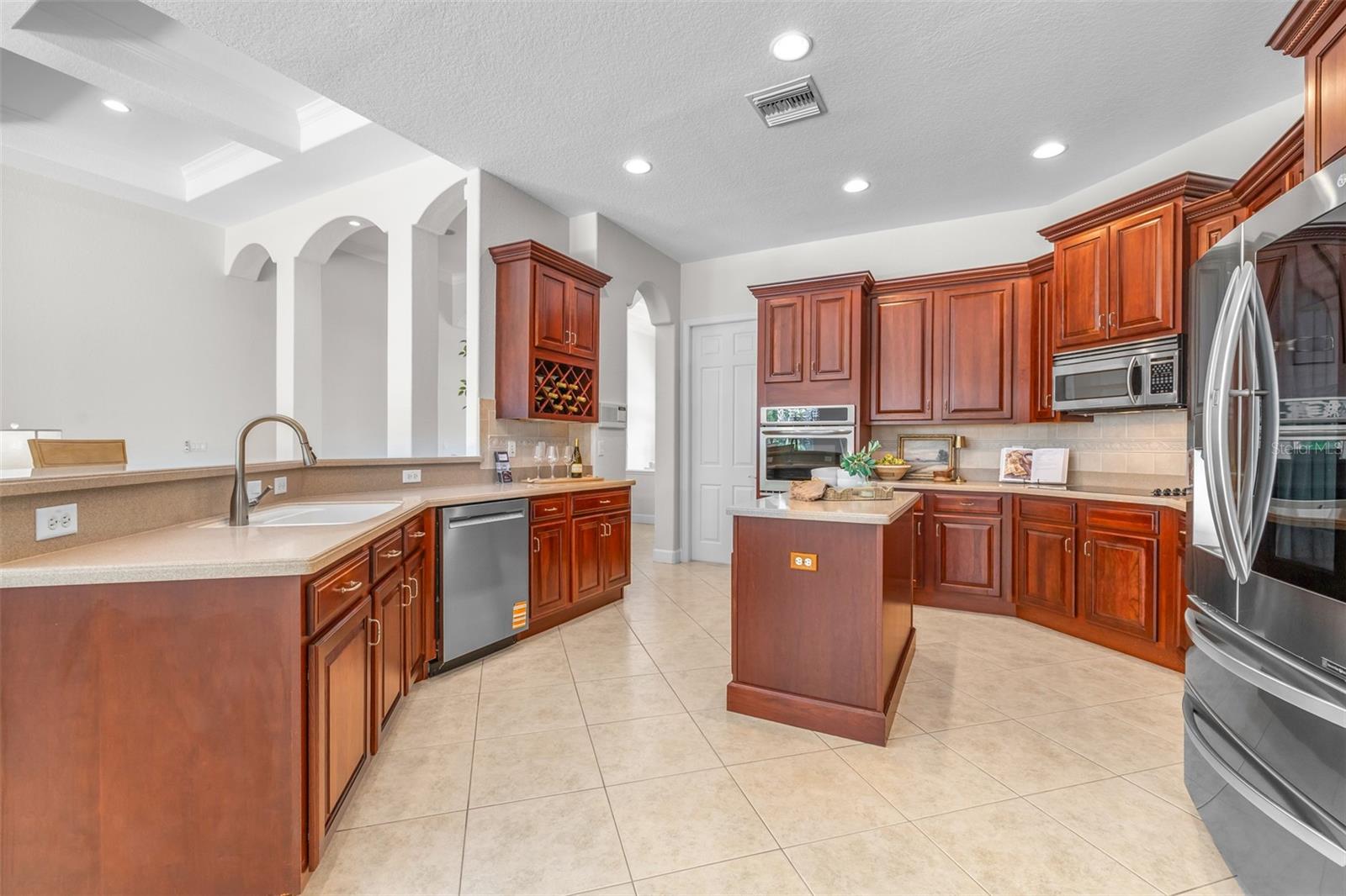 Spacious kitchen with rich wood cabinetry, extensive counter space and oversized breakfast bar