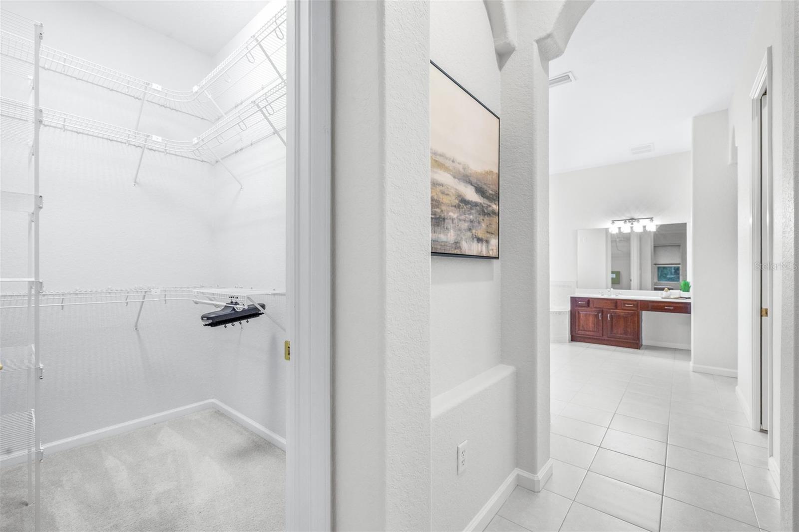 Spa-inspired primary bath with dual closets and separate water closet with additional cabinet space