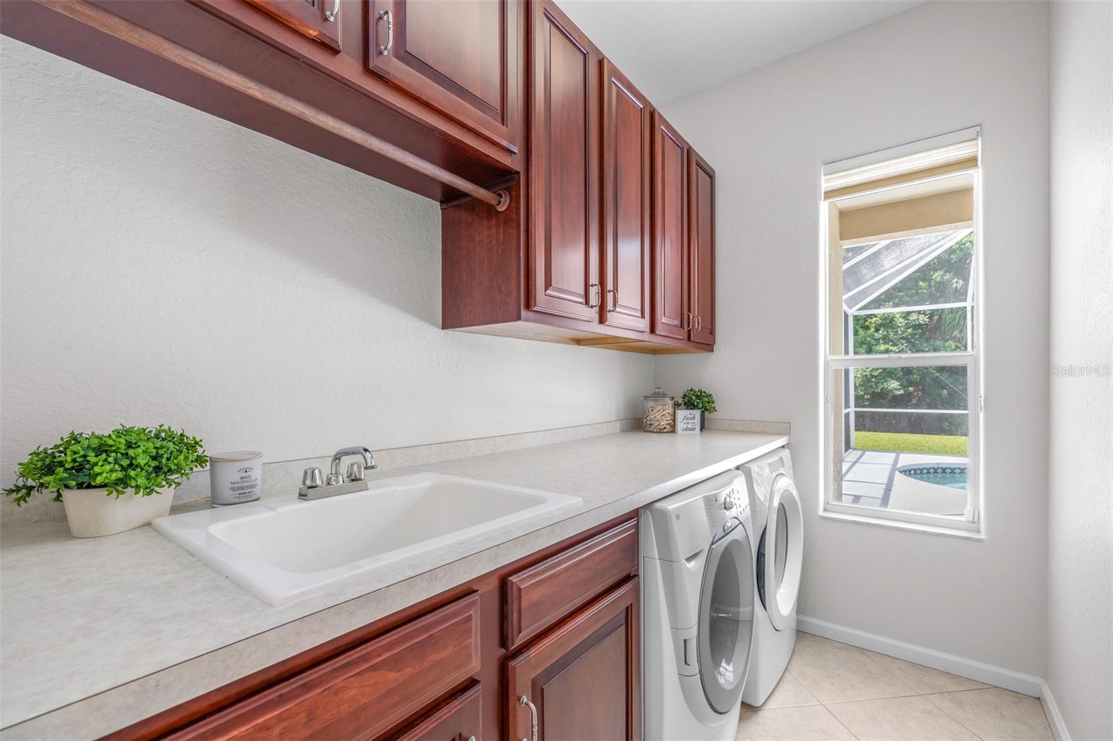 Large laundry room with additional built-in cabinetry and counter space ideal for storage and organization