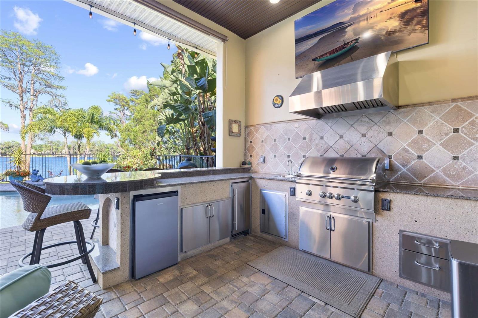 Outdoor Kitchen with Coyote Grill, Vent Hood, Beverage Fridge, Ice Maker and Sink