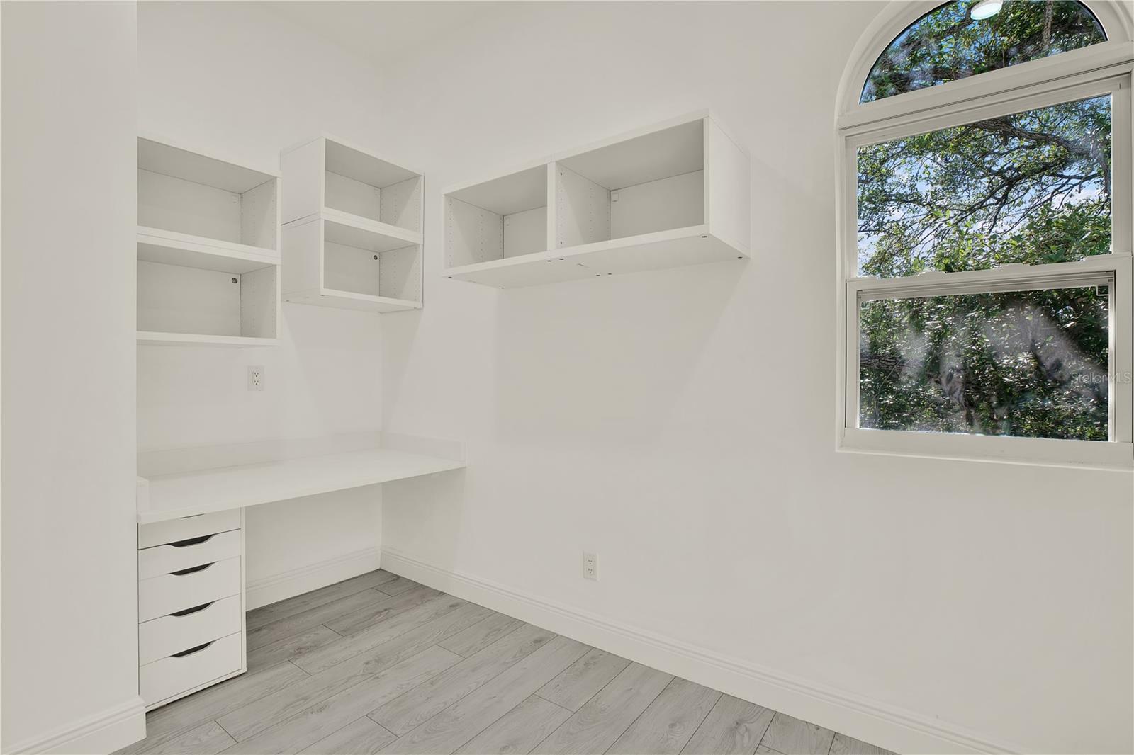 Dedicated office space with built-in desk and shelving.