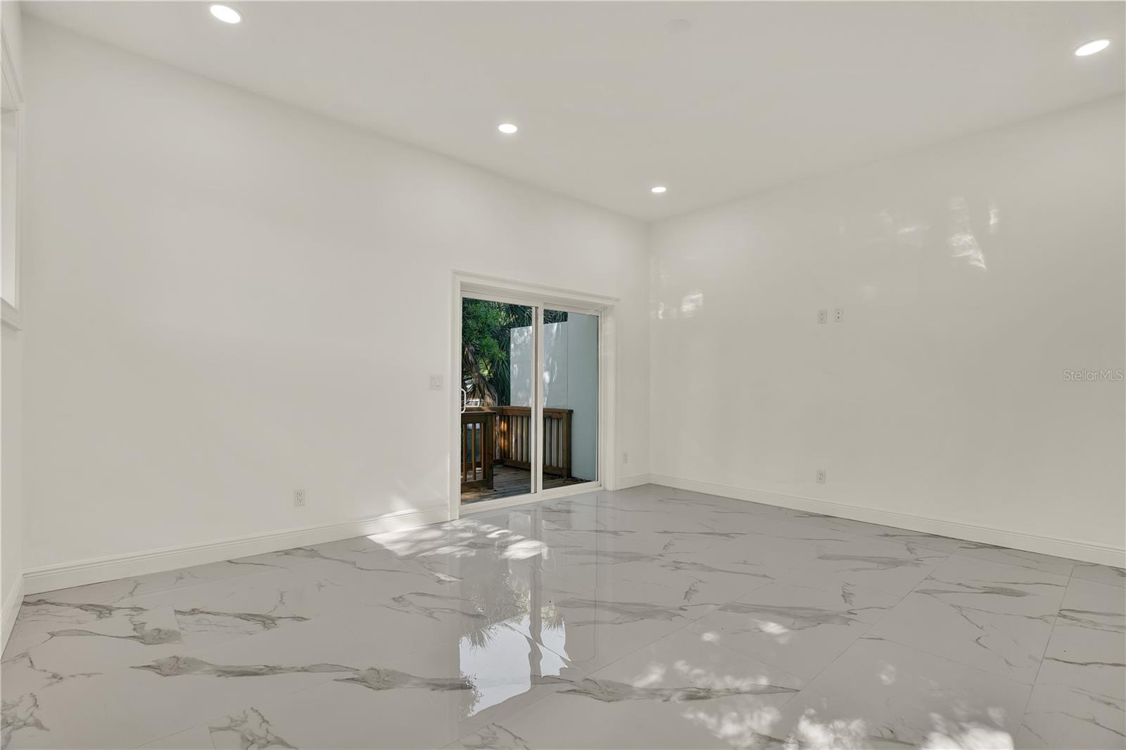 Large living room with sliders leading to backyard.