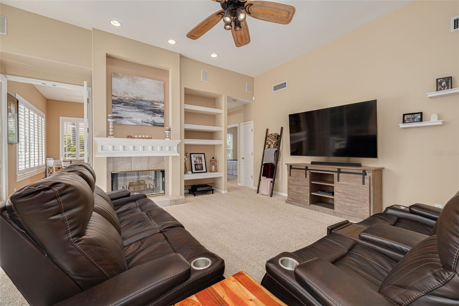 Family room with bonus room and dual fireplace on the left, entry to fourth bedroom and pool bath on the far left.