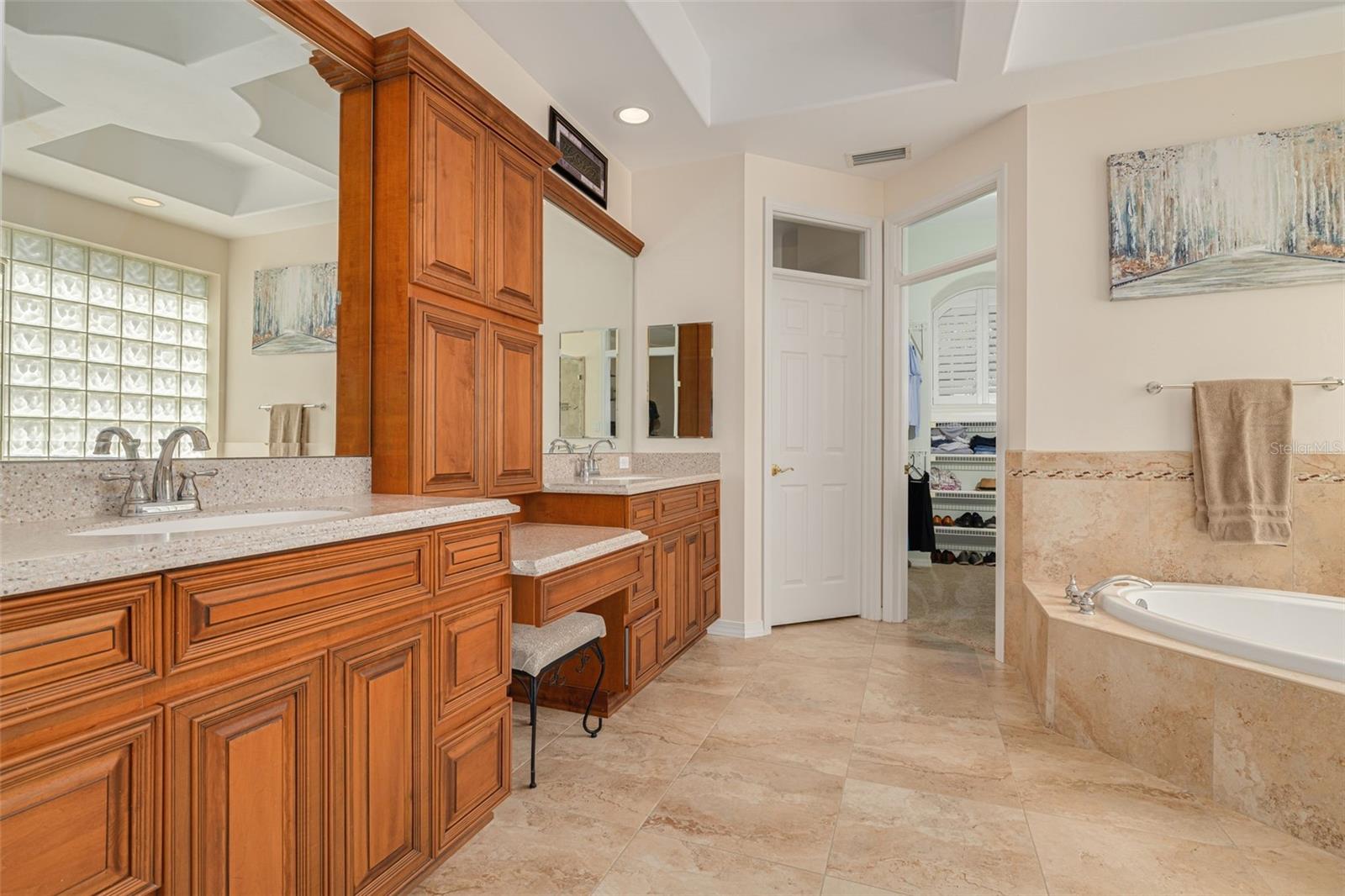 Updated primary bath with separate shower, sunken tub, dual sinks and center console storage