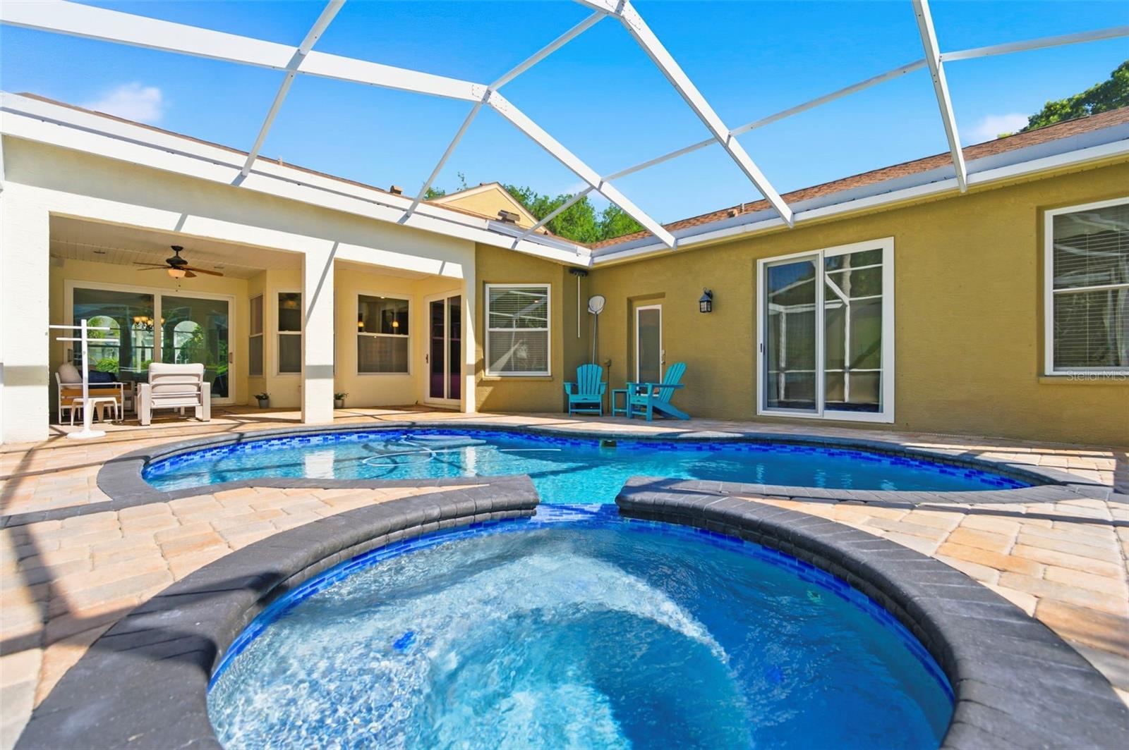 Step outside and into your own private resort-style retreat, where a sparkling screened-in pool and spa are surrounded by an expansive paver deck and covered lanai. The seamless indoor-outdoor flow creates the perfect setting for relaxing mornings, sunny afternoons, or evening gatherings. With lush surroundings and complete privacy, this space is designed for both entertaining and unwinding in true Florida style.