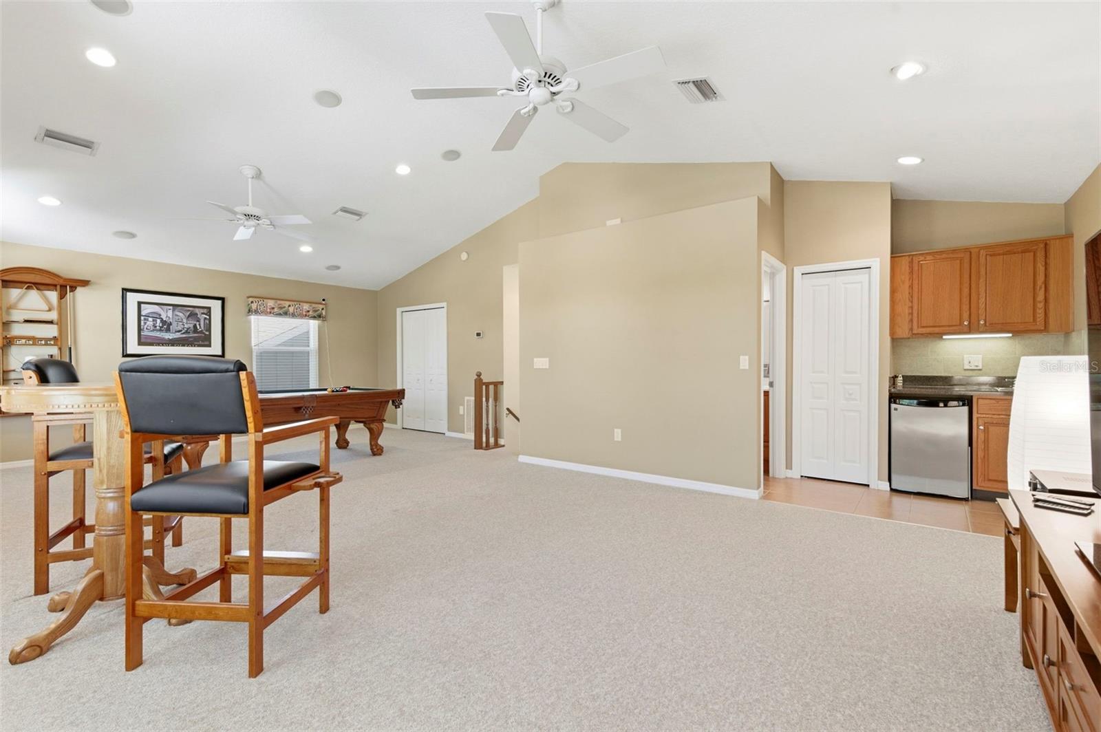 Expansive bonus room designed for entertaining and relaxation, featuring soaring ceilings, abundant natural light, and ample space for a game room, media lounge, or private retreat. Complete with a pool table and room for additional seating or activities, this versatile space is perfect for hosting, unwinding, or creating the ultimate entertainment zone.