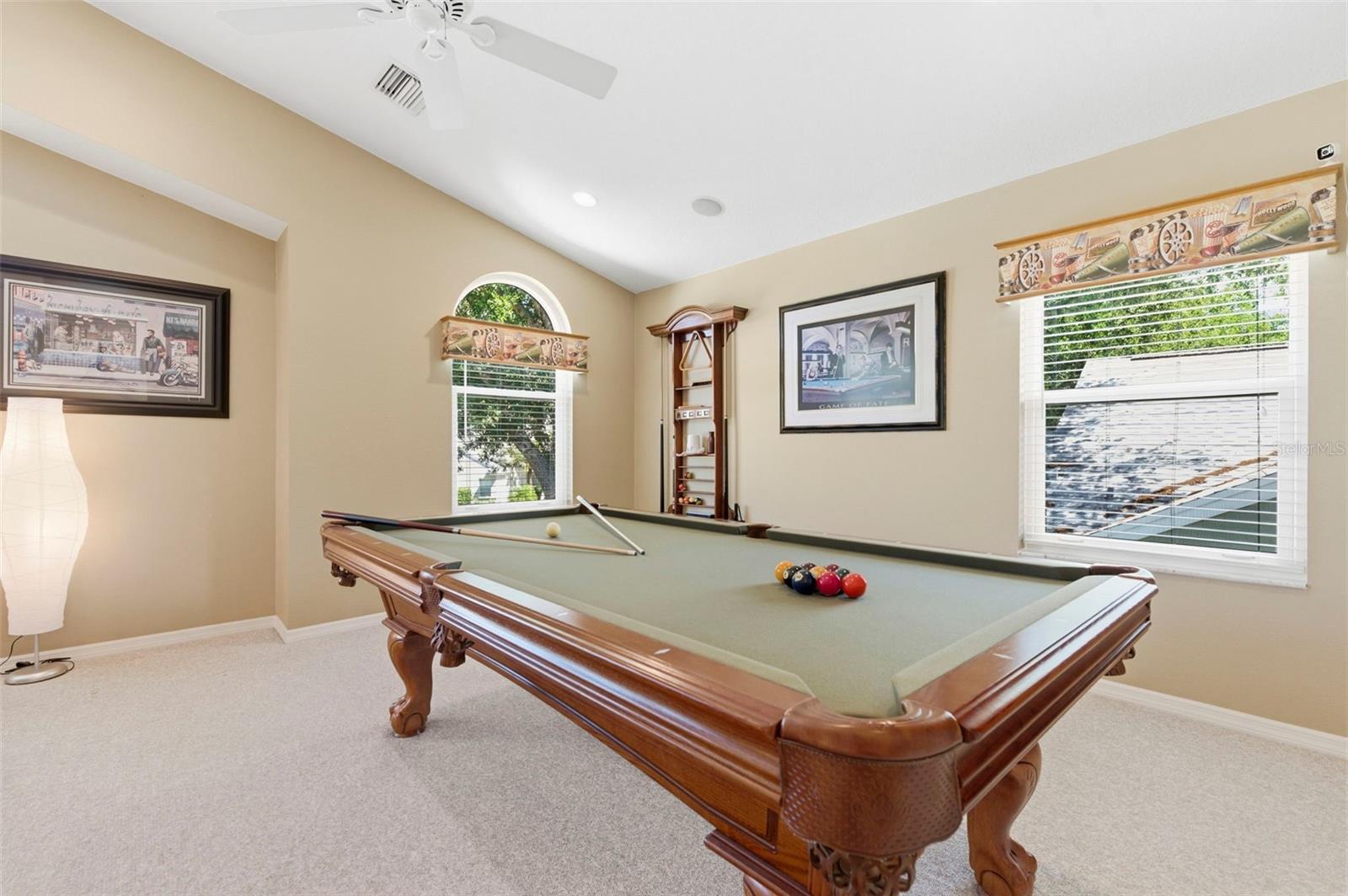 Expansive bonus room designed for entertaining and relaxation, featuring soaring ceilings, abundant natural light, and ample space for a game room, media lounge, or private retreat. Complete with a pool table and room for additional seating or activities, this versatile space is perfect for hosting, unwinding, or creating the ultimate entertainment zone.