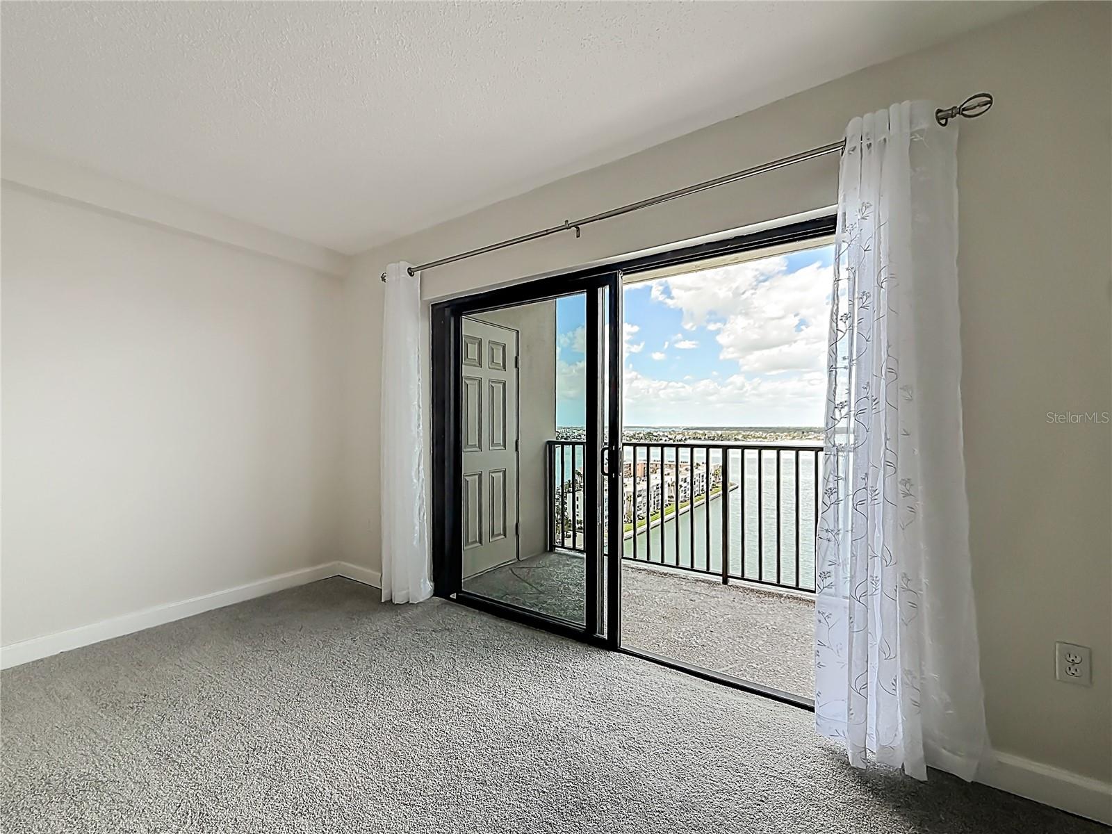 closer look at the primary bedroom sliders out to the balcony