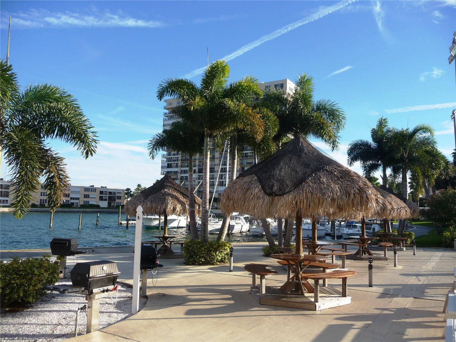 Tiki huts  with grills by the clubhouse and marina