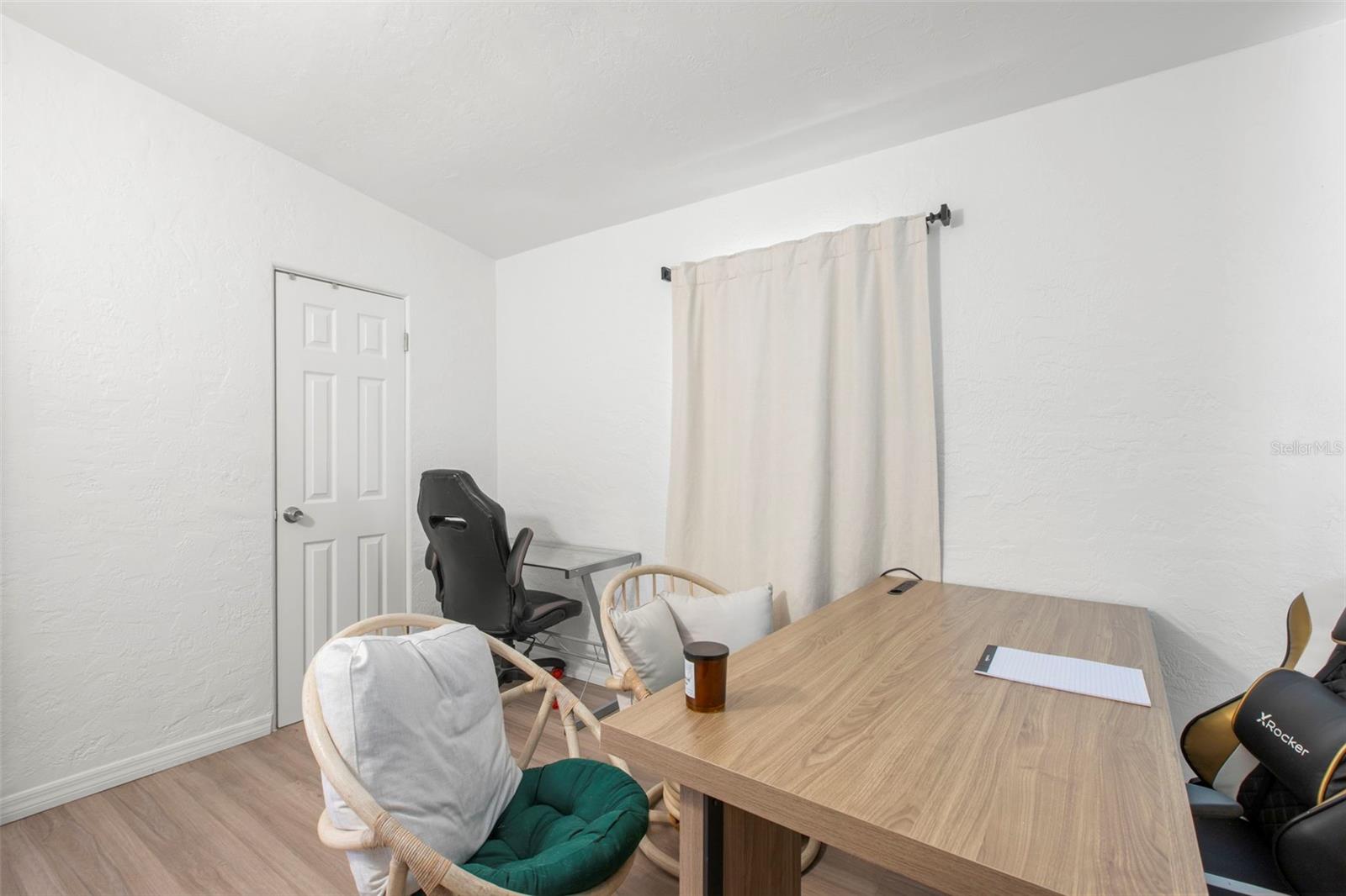A built-in closet and laminate flooring enhance the functionality in this bright secondary bedroom.