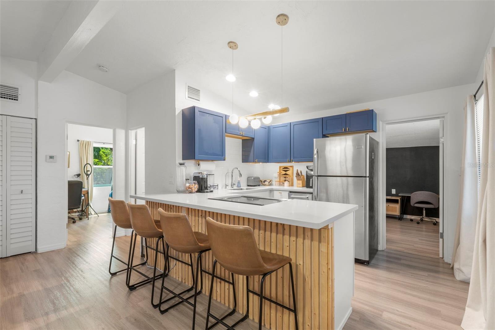 Corian countertops and custom wood-accent island create a stylish focal point.