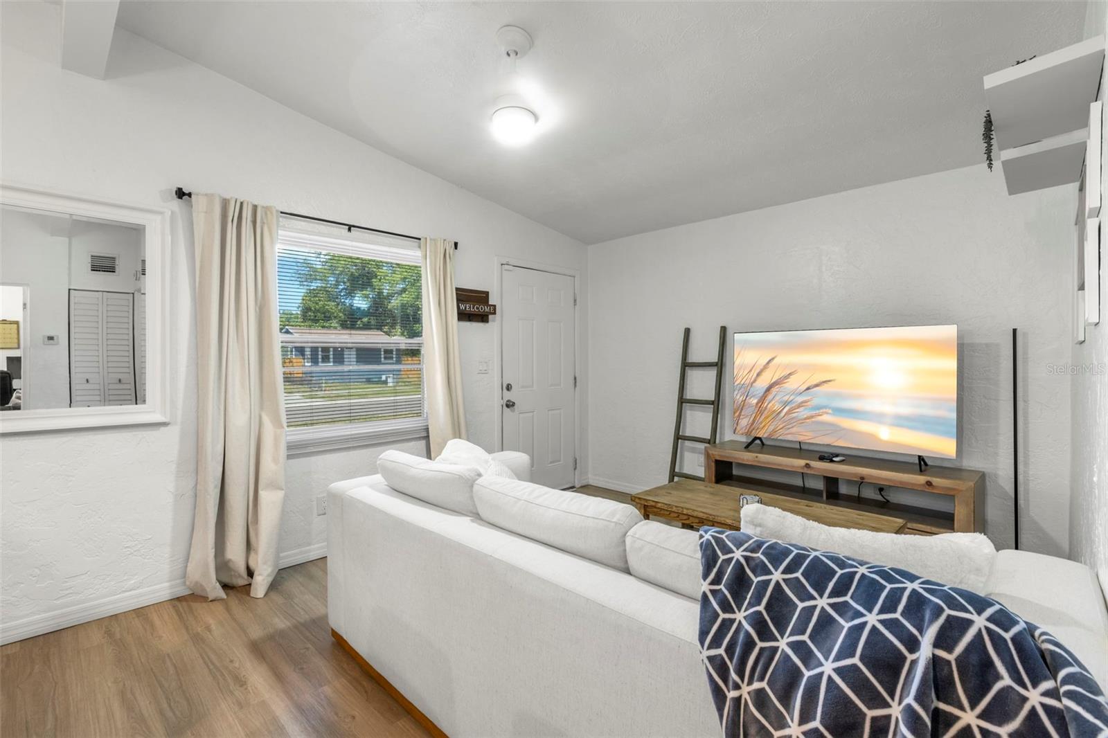 Bright and inviting living room with durable laminate flooring and abundant natural light.