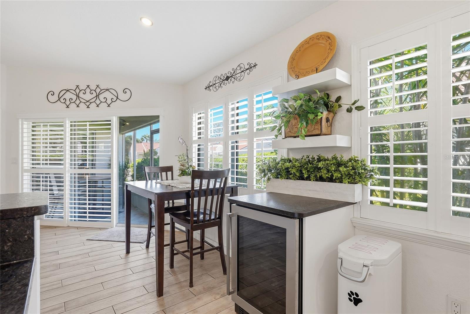 Beverage refrigerator and dinette overlooking the lush rear yard.
